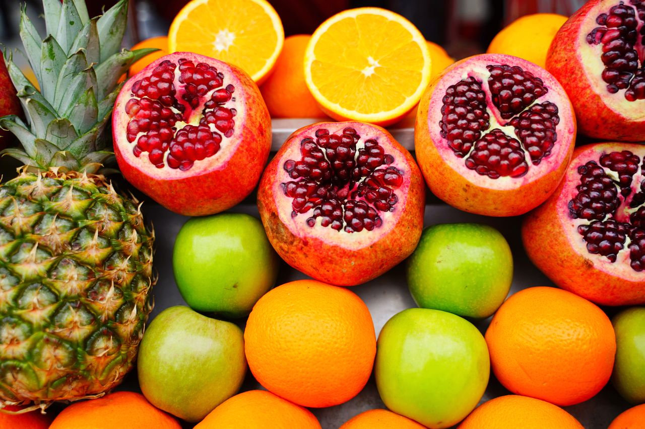 Contact A colorful assortment of fresh fruits including pomegranates, oranges, and apples, ideal for healthy eating themes.